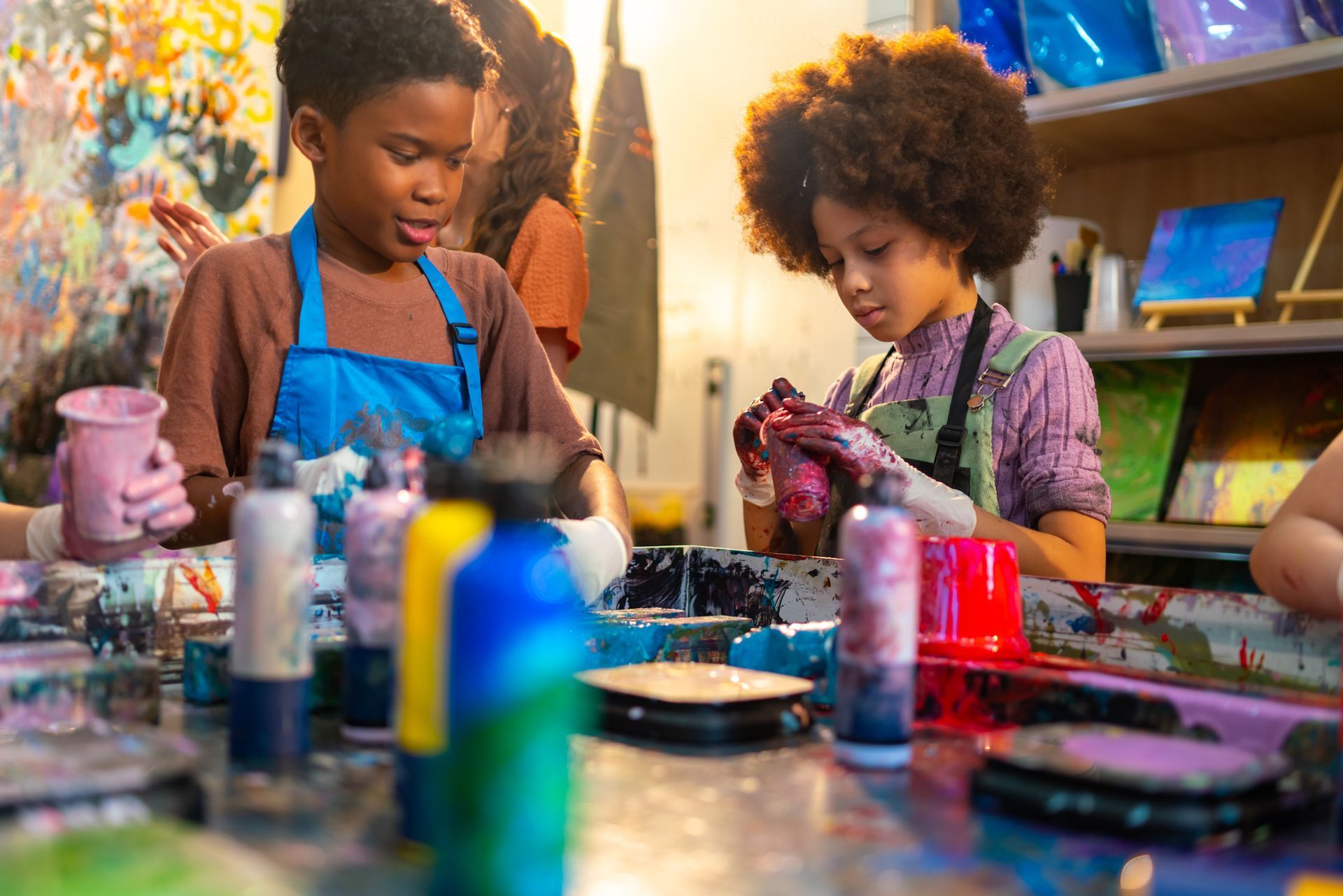 Children at an art class, painting with hands and colorful paints.
