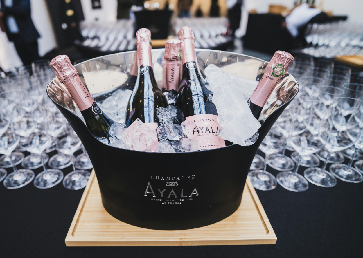 A bucket filled with ice and bottles of ayala champagne
