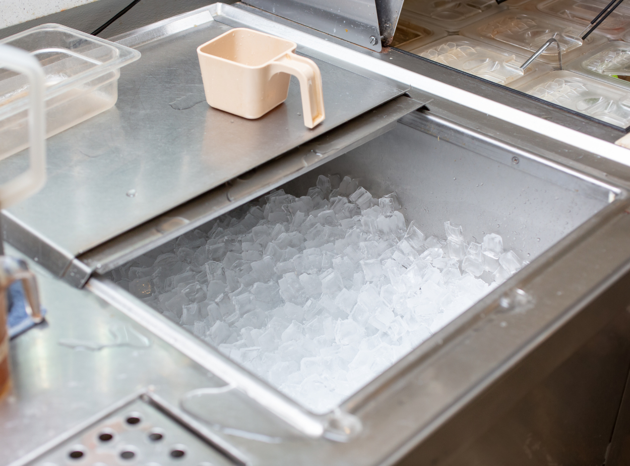 A scoop is sitting on top of a tray of ice cubes.