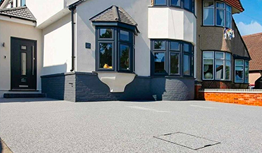 a large house with a concrete driveway in front of it .