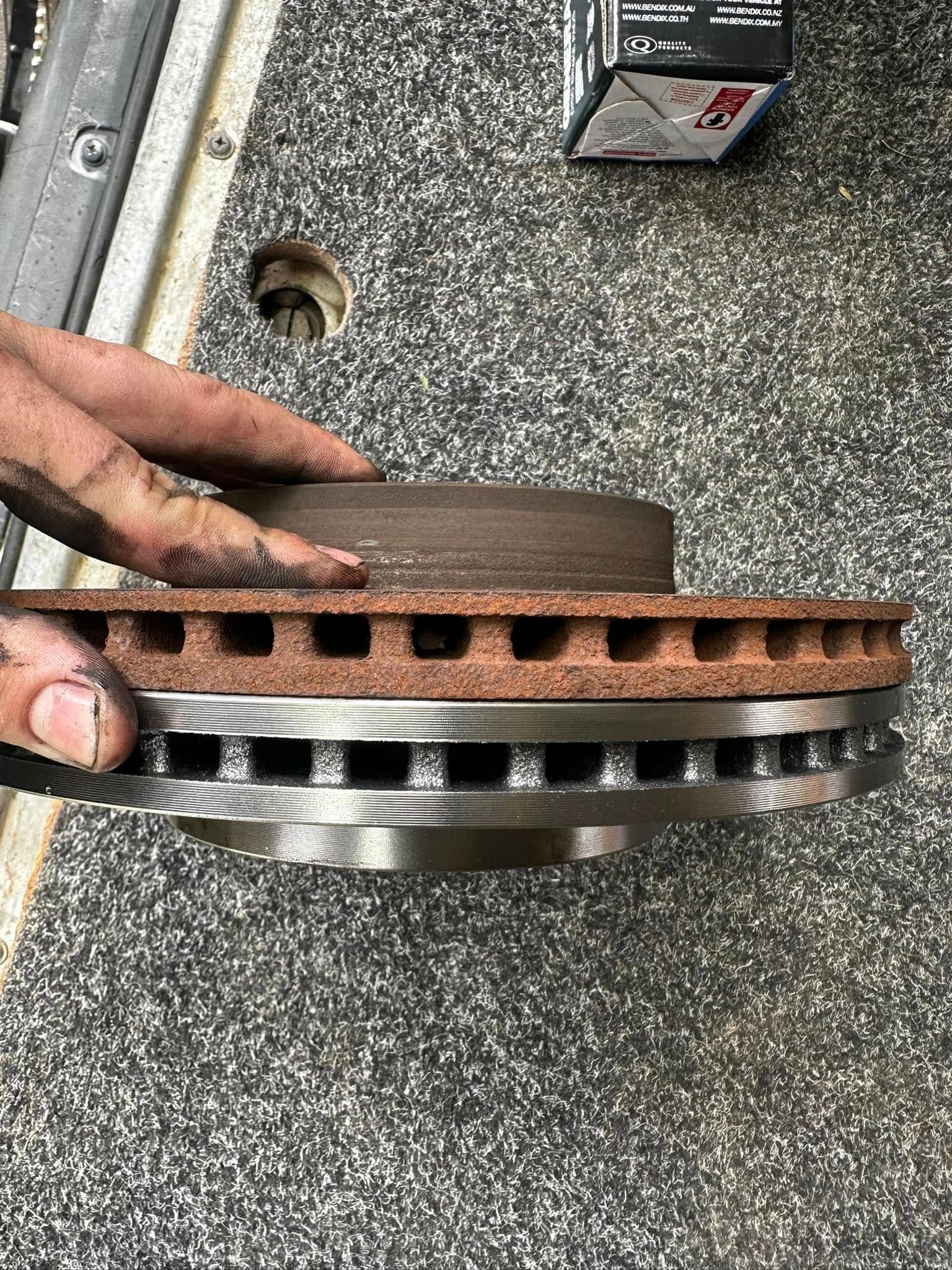 Person's Hand Holding a Rusty Brake Rotor With Vents — JDM Mobile Mechanical in Bankstown, NSW