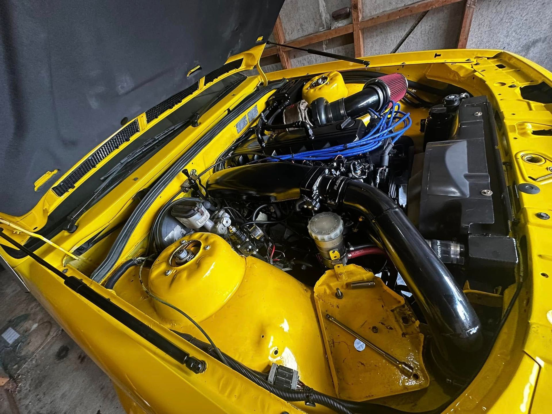 Yellow Car Engine Bay With Black Engine Components and Blue Wires — JDM Mobile Mechanical in Holsworthy, NSW