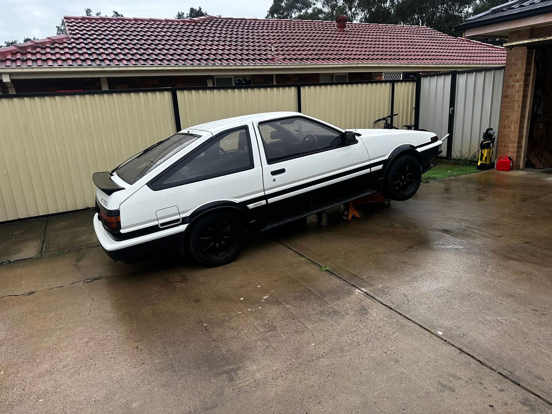 White and Black Toyota Ae86 Car on a Wet Driveway — JDM Mobile Mechanical in Bankstown, NSW