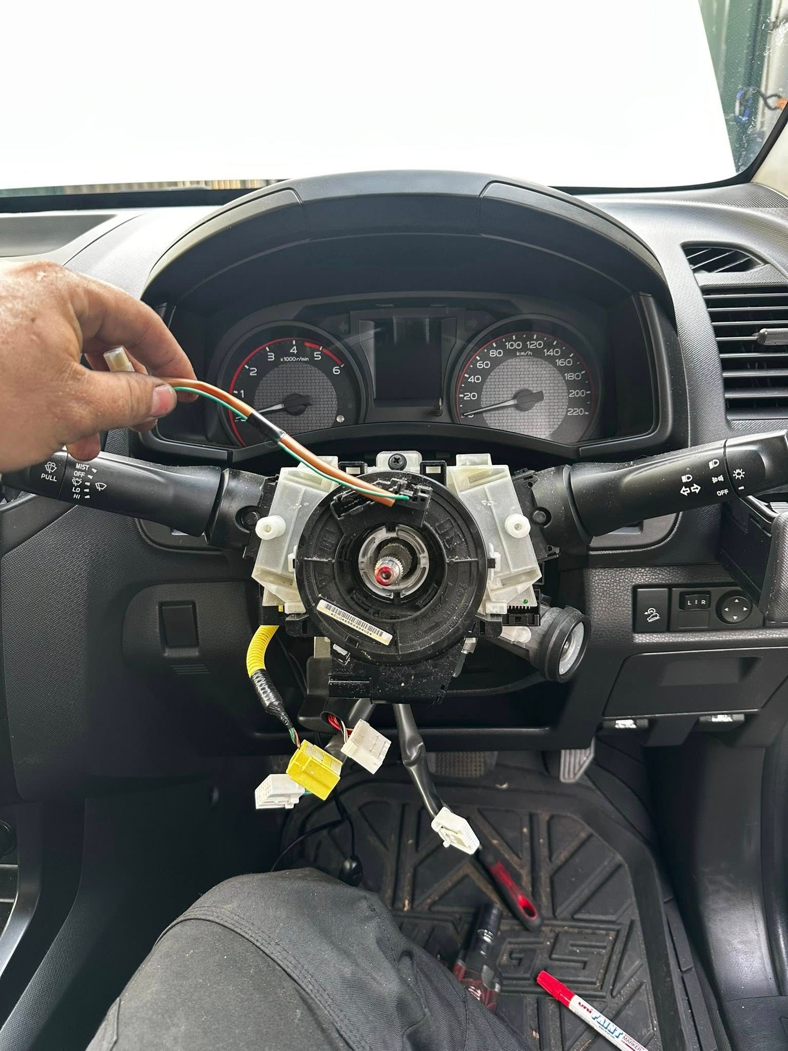 Person Working on a Car Steering Column, Holding a Wire — JDM Mobile Mechanical in Holsworthy, NSW