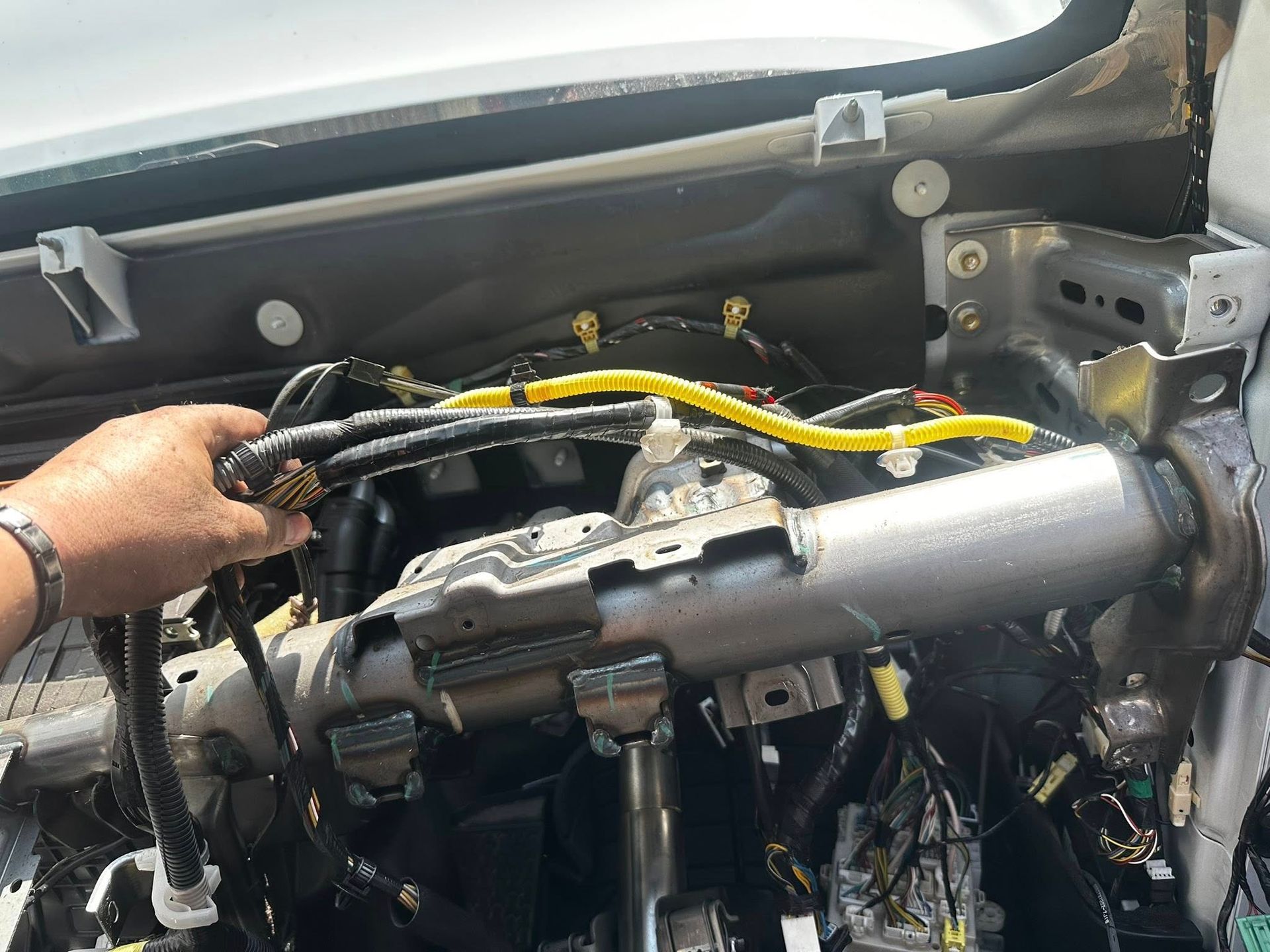 Hand Reaching Toward Car Dashboard Wiring — JDM Mobile Mechanical in Campbelltown, NSW