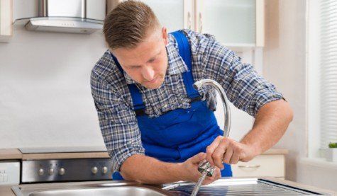 Home plumbing — Repairman Installing Faucet in Salinas, CA