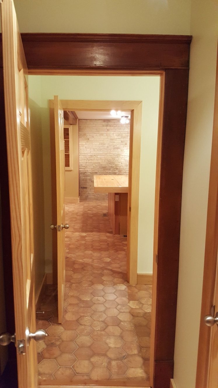 Open doorways lead to a room with hexagonal floor tiles.