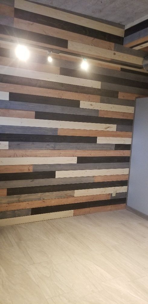 Wooden plank wall with three lights. Light wood flooring.