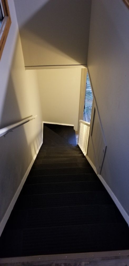 Stairwell with black stairs and gray walls, viewed from above.