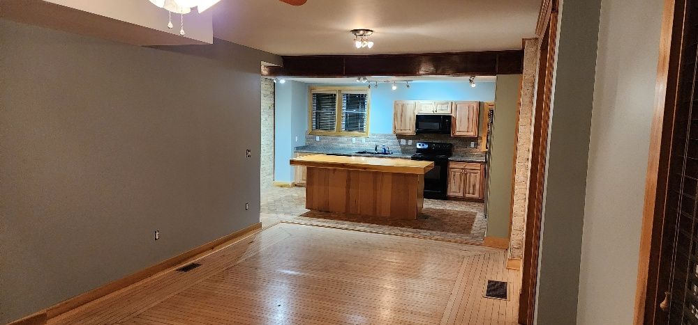 Interior view of a kitchen under renovation, with a wooden island and cabinets.