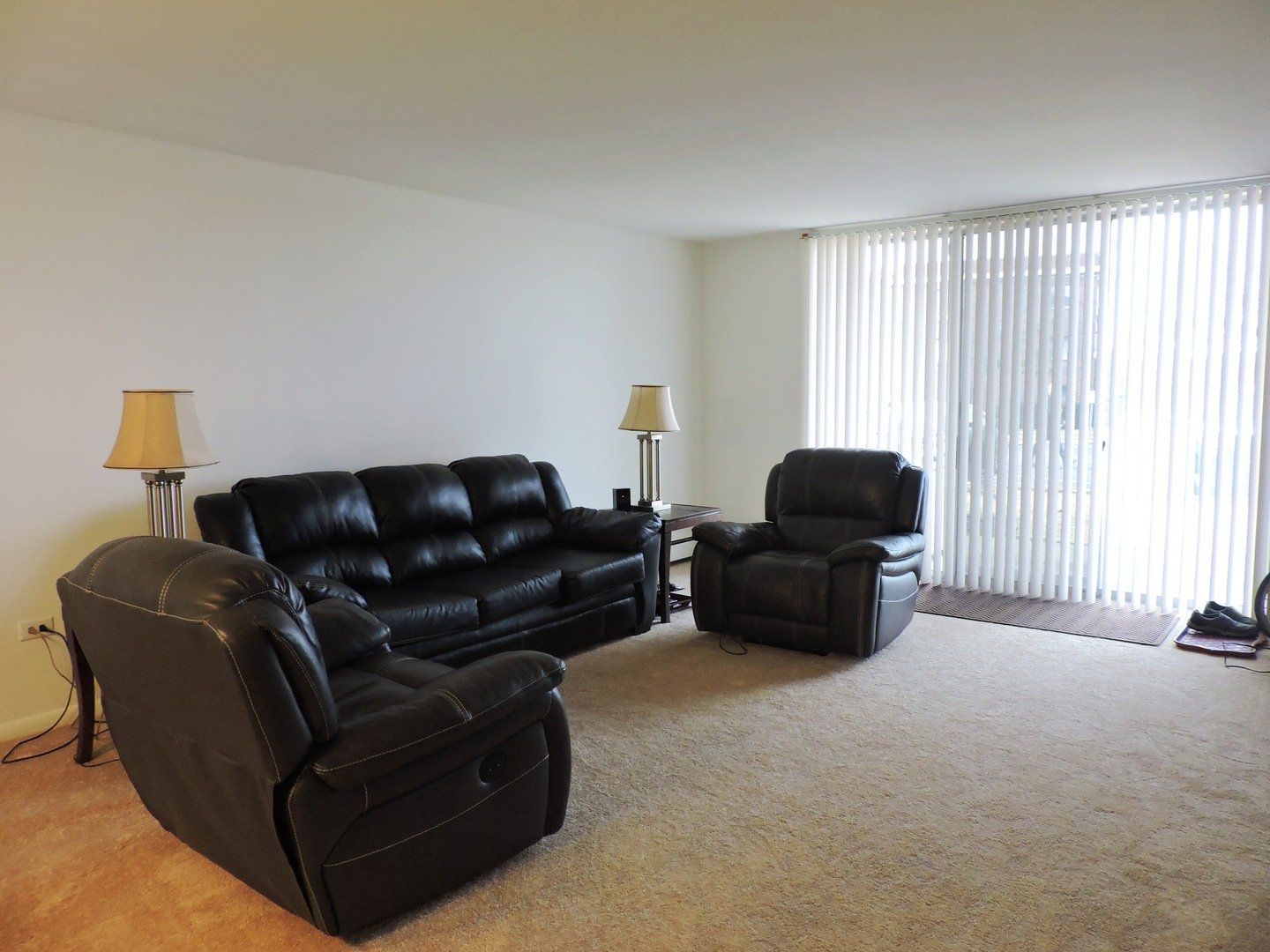 Carpeted living room with large balcony door