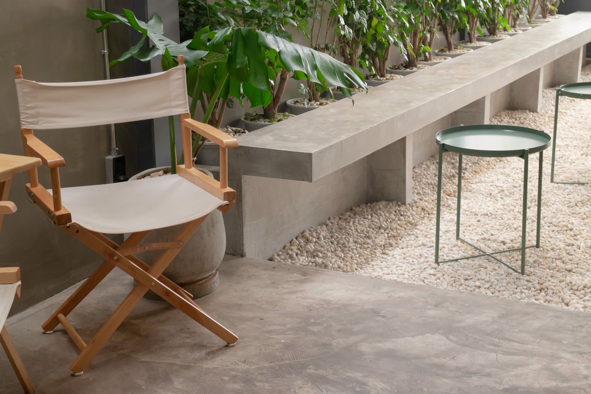 A director 's chair is sitting next to a table on a patio.
