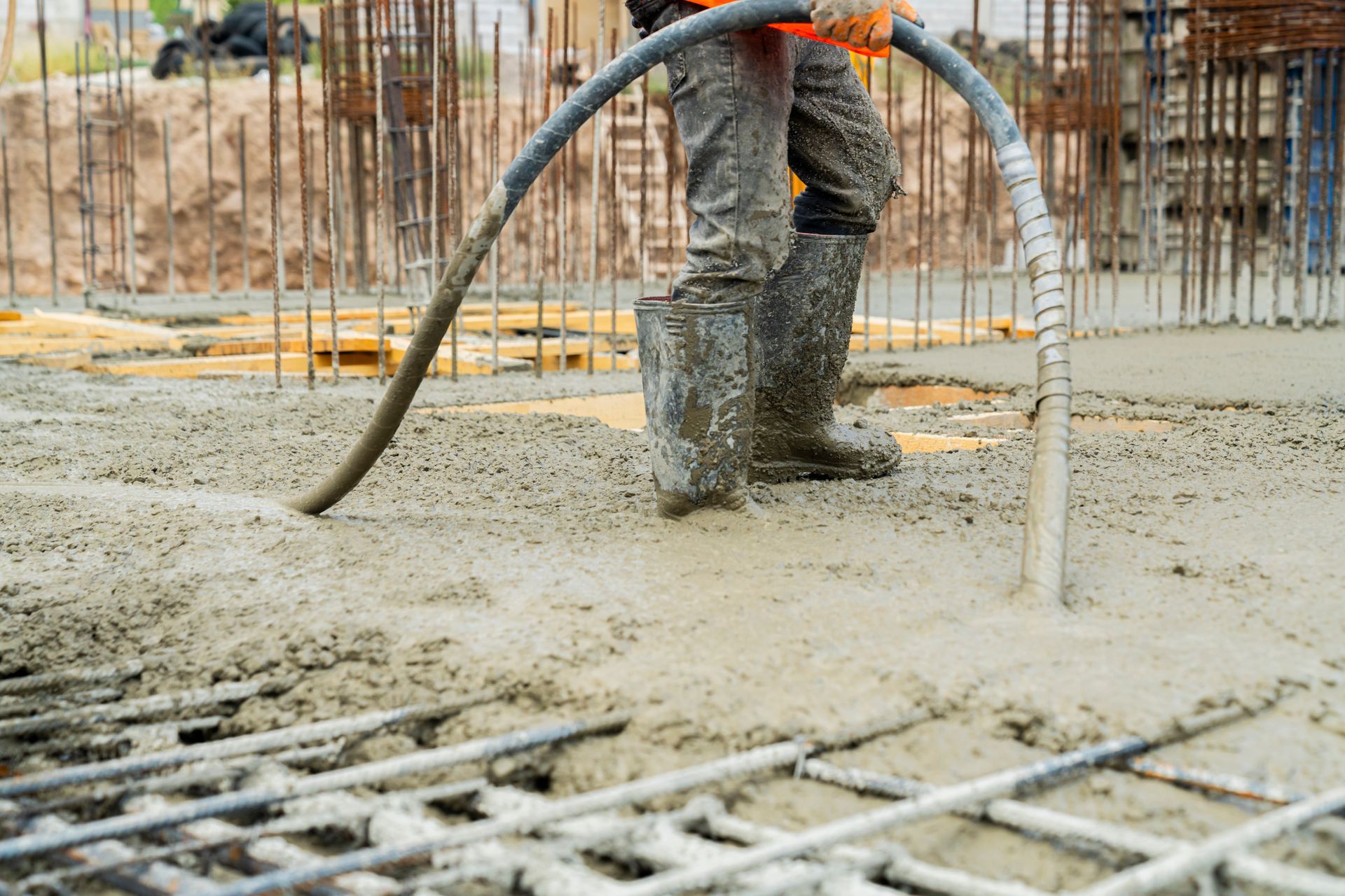A construction worker is pouring concrete on a construction site.