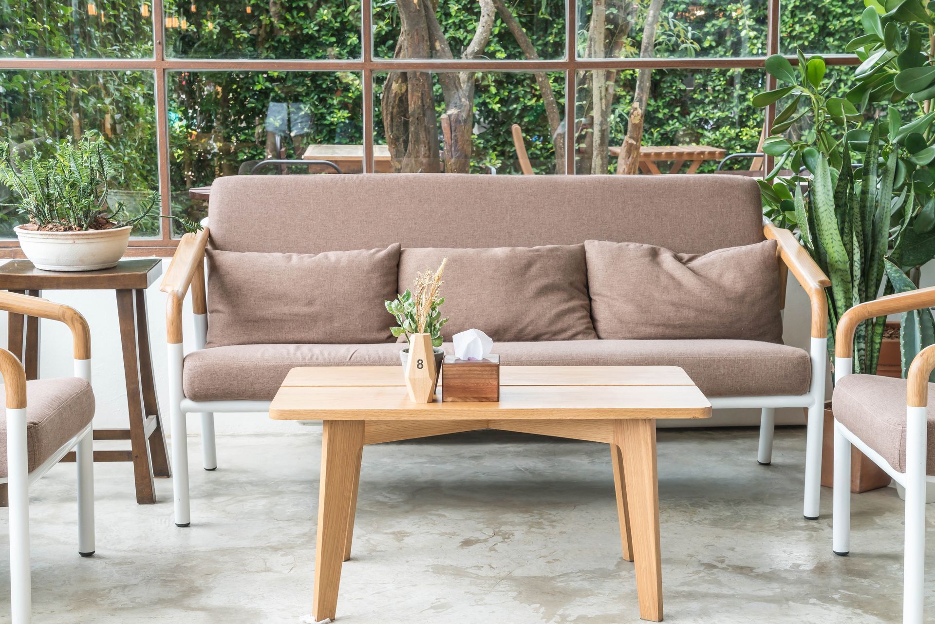 A living room with a couch , chairs , and a table.
