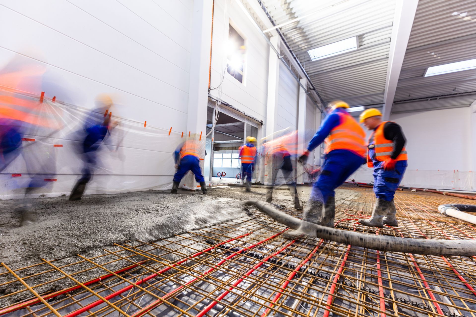A group of construction workers are pouring concrete into a building.