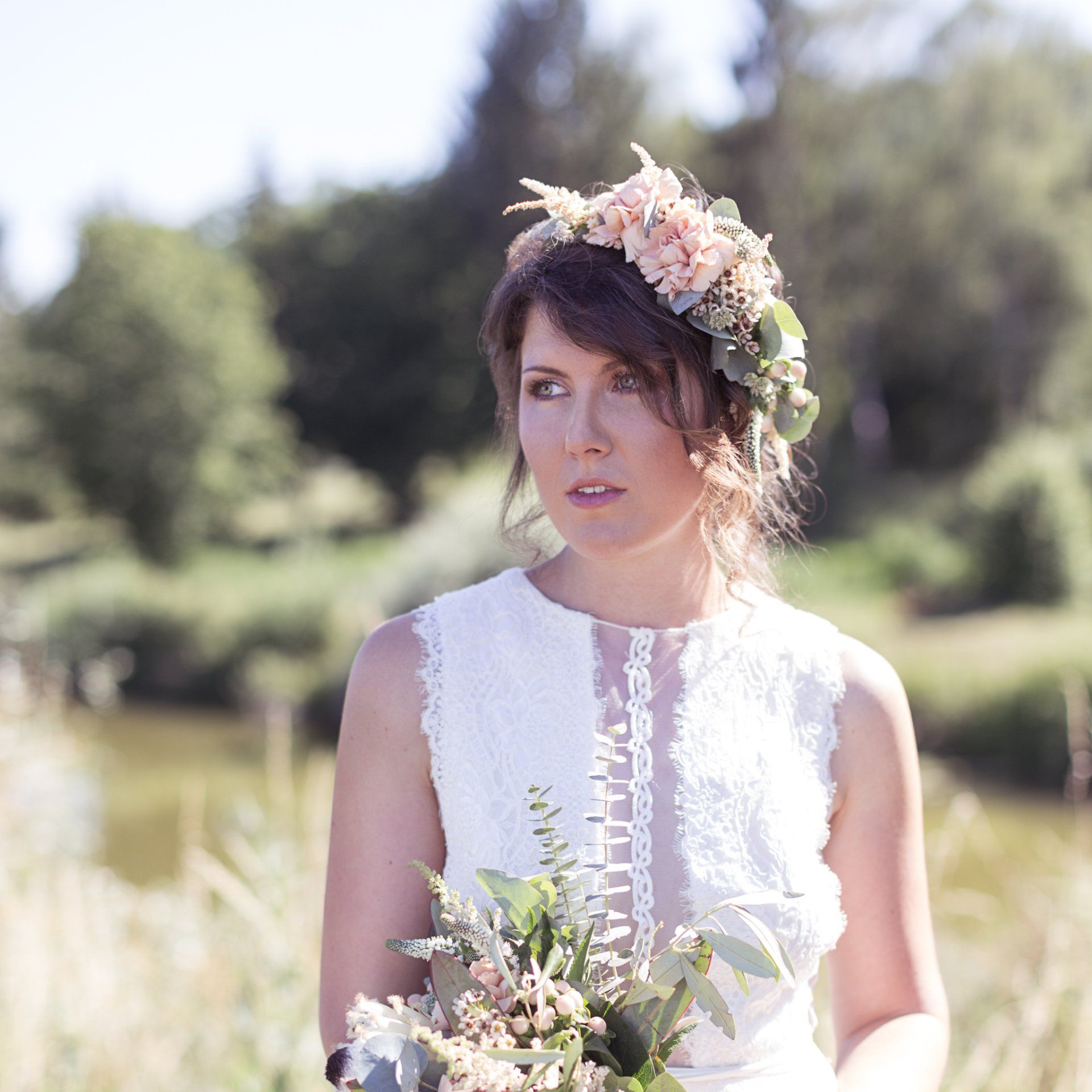Eine Frau in einem weißen Kleid hält einen Blumenstrauß