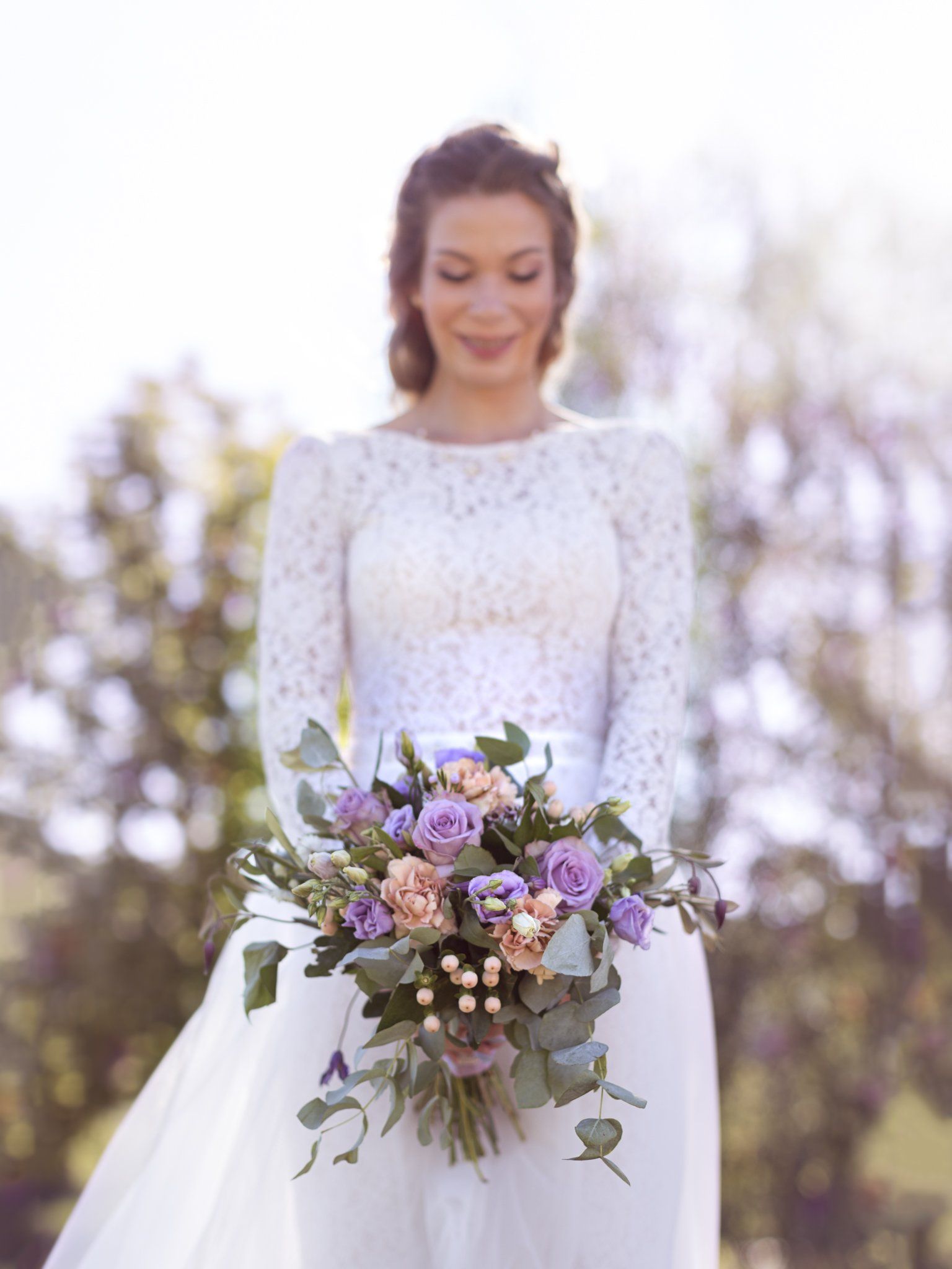 Eine Braut in einem weißen Kleid hält einen Blumenstrauß.