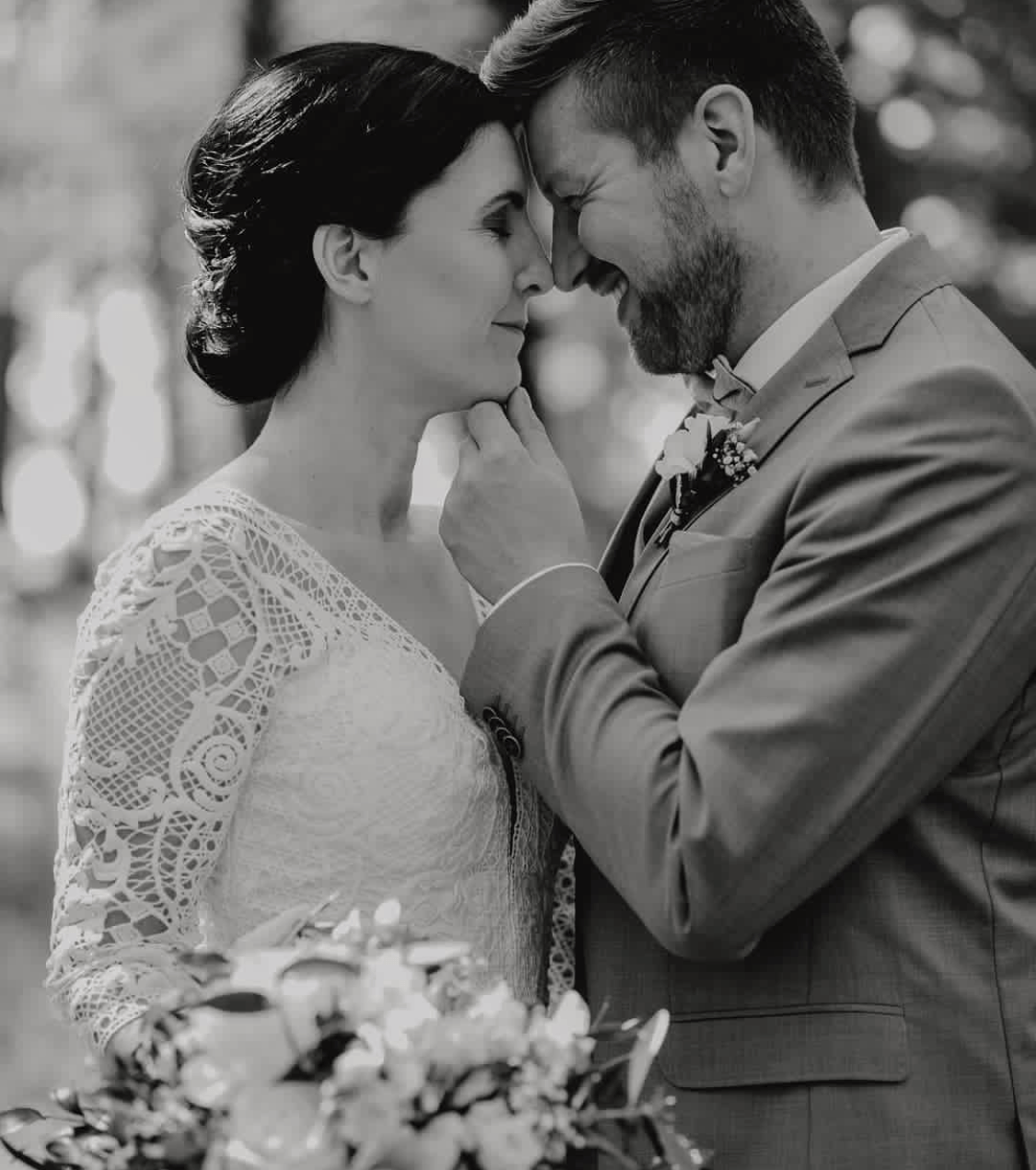 Auf einem Schwarzweißfoto küssen sich Braut und Bräutigam.