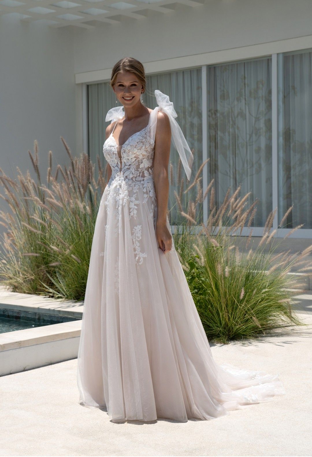 Eine Frau in einem Brautkleid steht vor einem Gebäude.