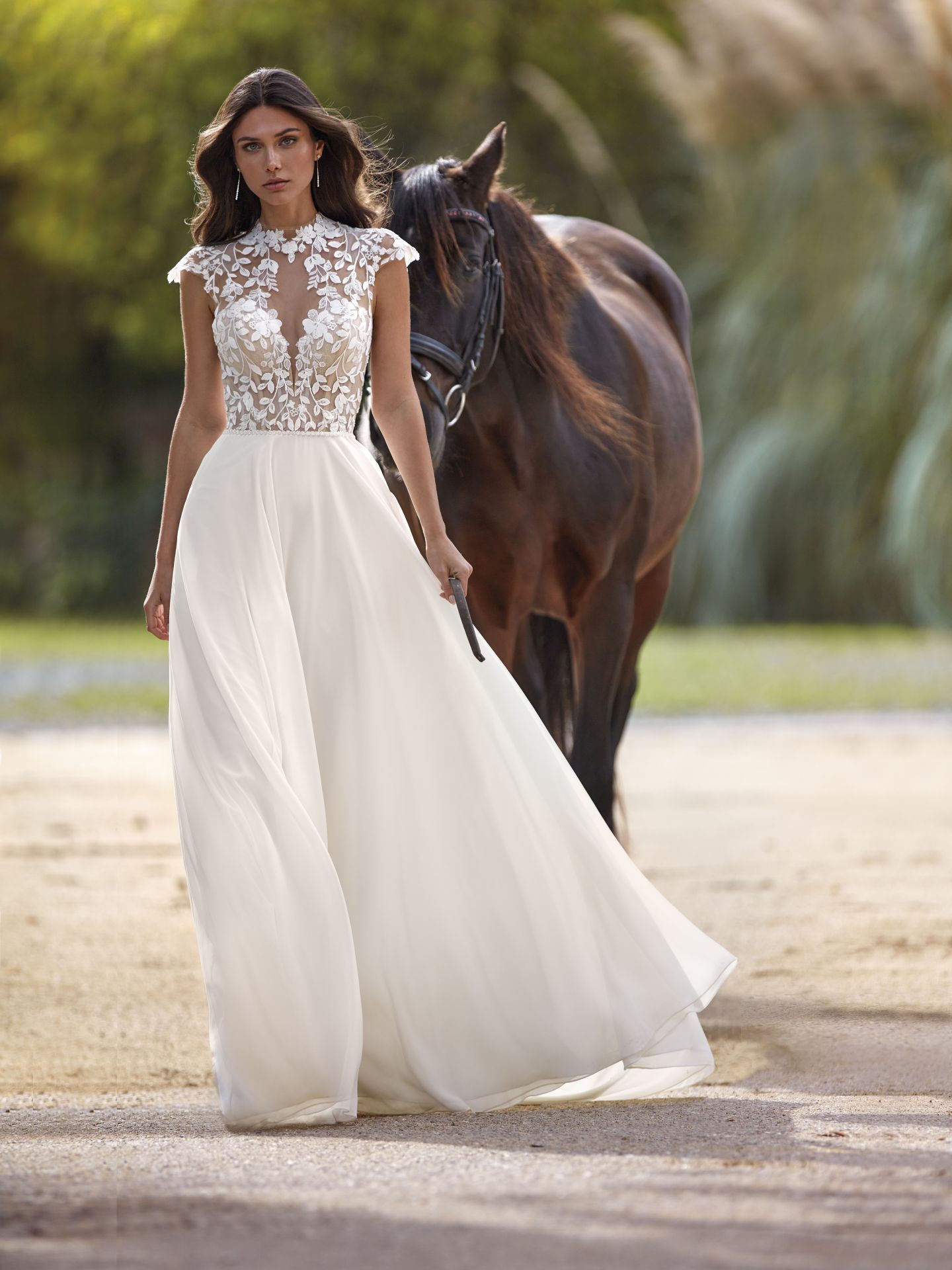 Eine Frau in einem Brautkleid steht neben einem Pferd.