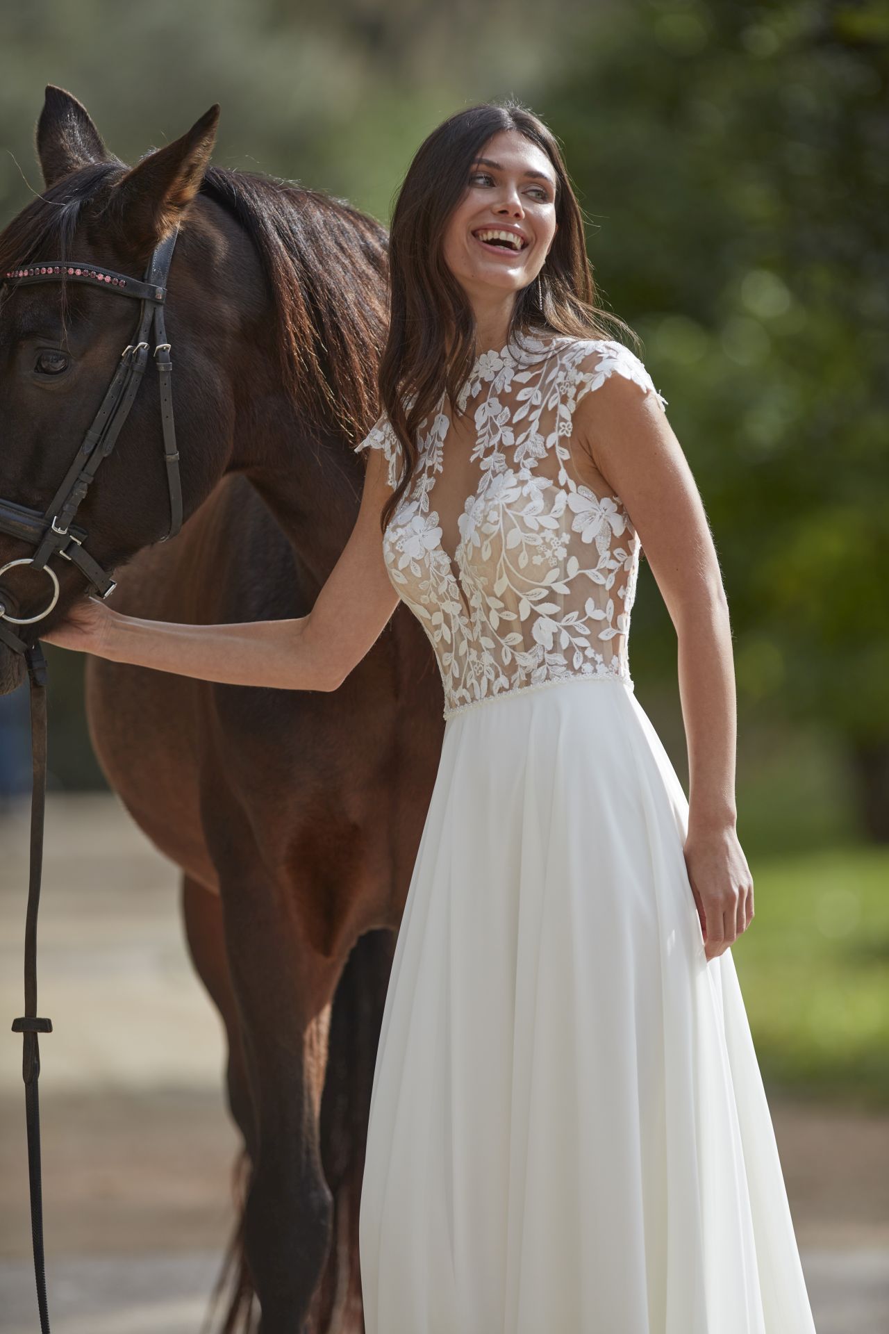 Eine Frau in einem Brautkleid steht neben einem Pferd.