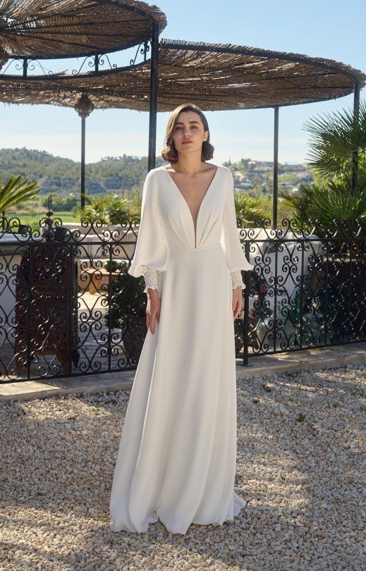 Eine Frau in einem weißen Brautkleid steht vor einem Pavillon.