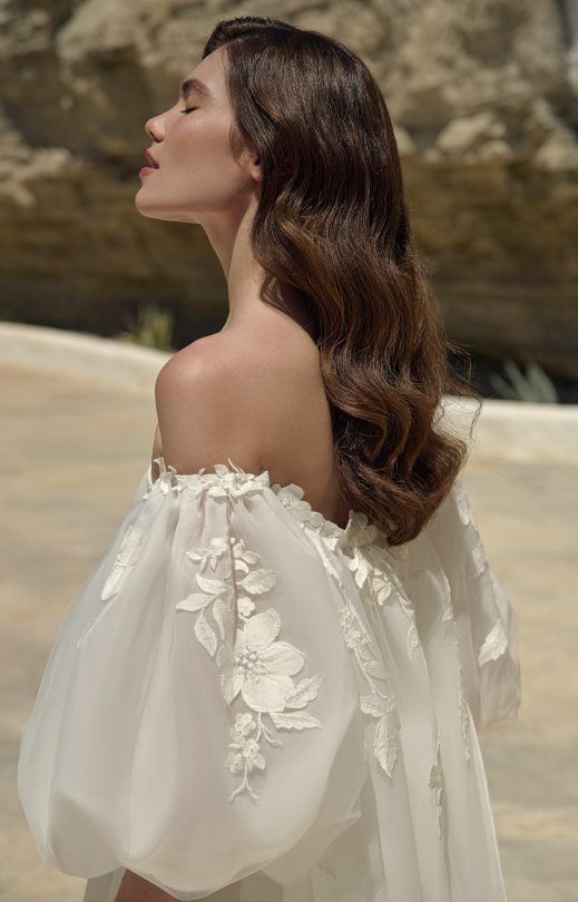 Eine Frau trägt ein weißes Brautkleid mit Puffärmeln.