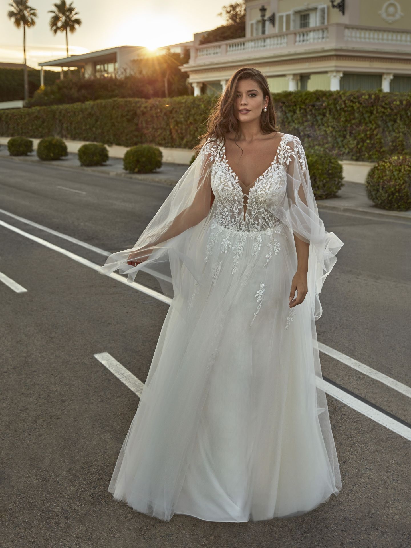 Eine Frau in einem weißen Brautkleid steht auf einer Straße.