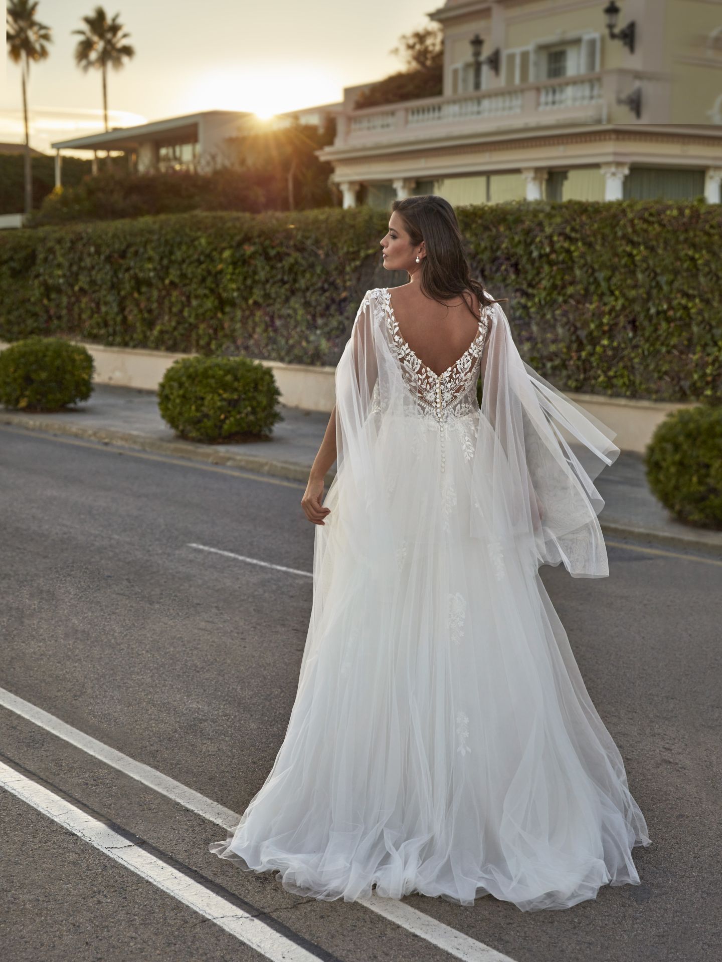 Eine Frau in einem Brautkleid geht die Straße entlang.