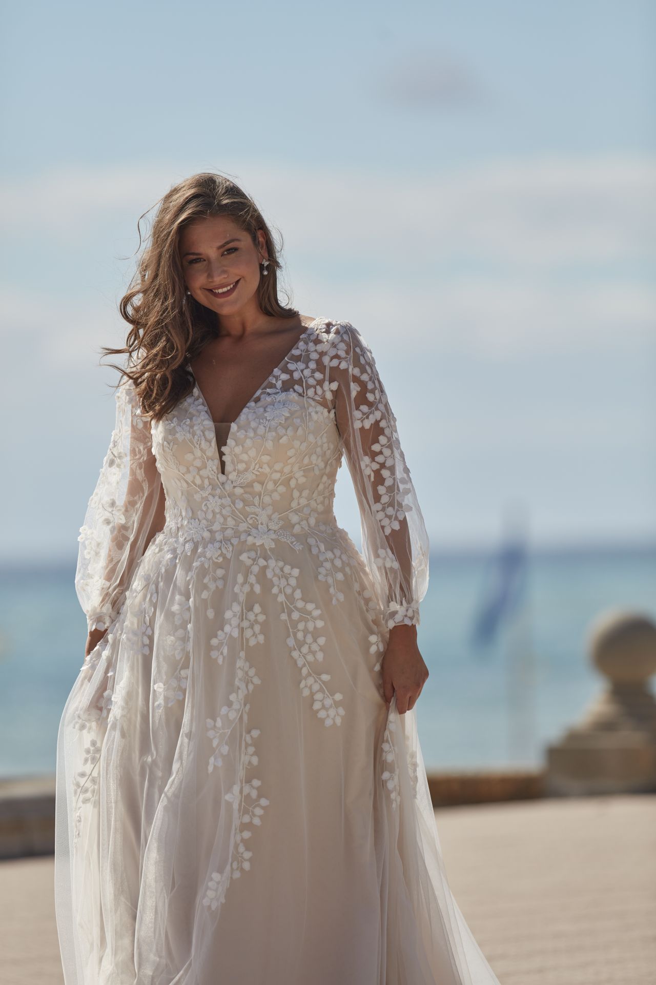 Eine Frau in einem Brautkleid steht an einem Strand.