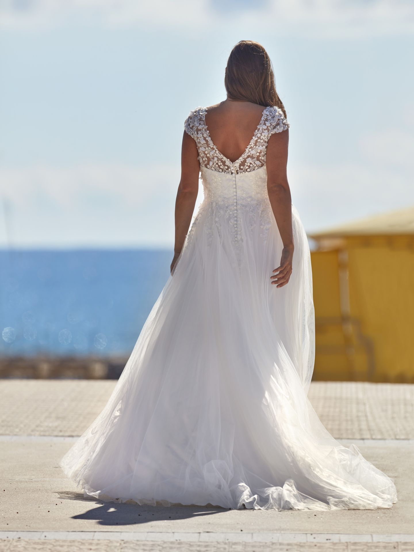 Zu sehen ist der Rücken einer Frau im Brautkleid.