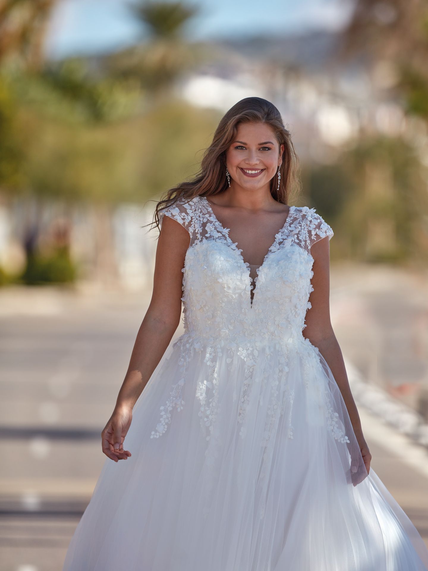 Eine Frau in einem weißen Brautkleid steht auf einer Straße.