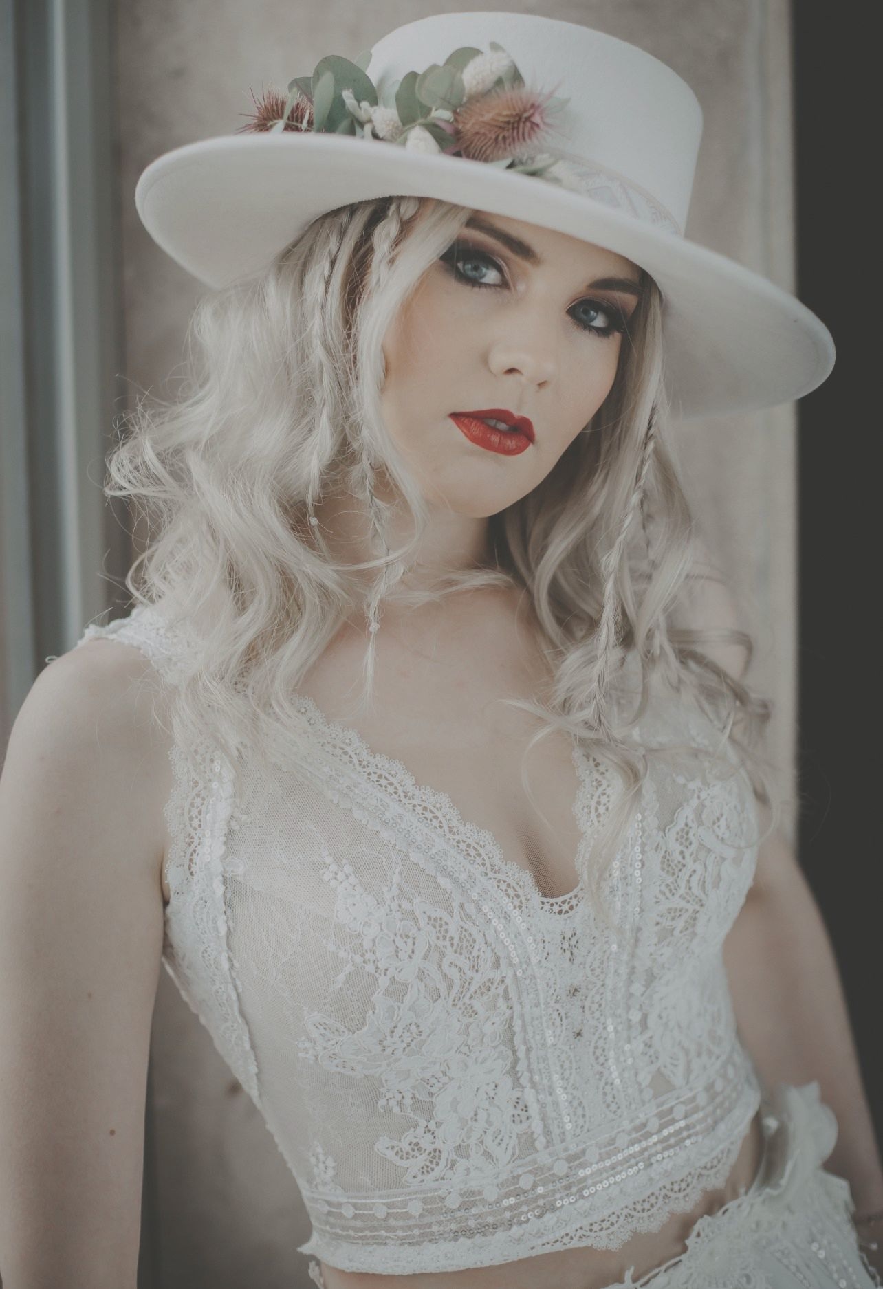 Die Frau trägt einen weißen Hut und ein weißes Oberteil.