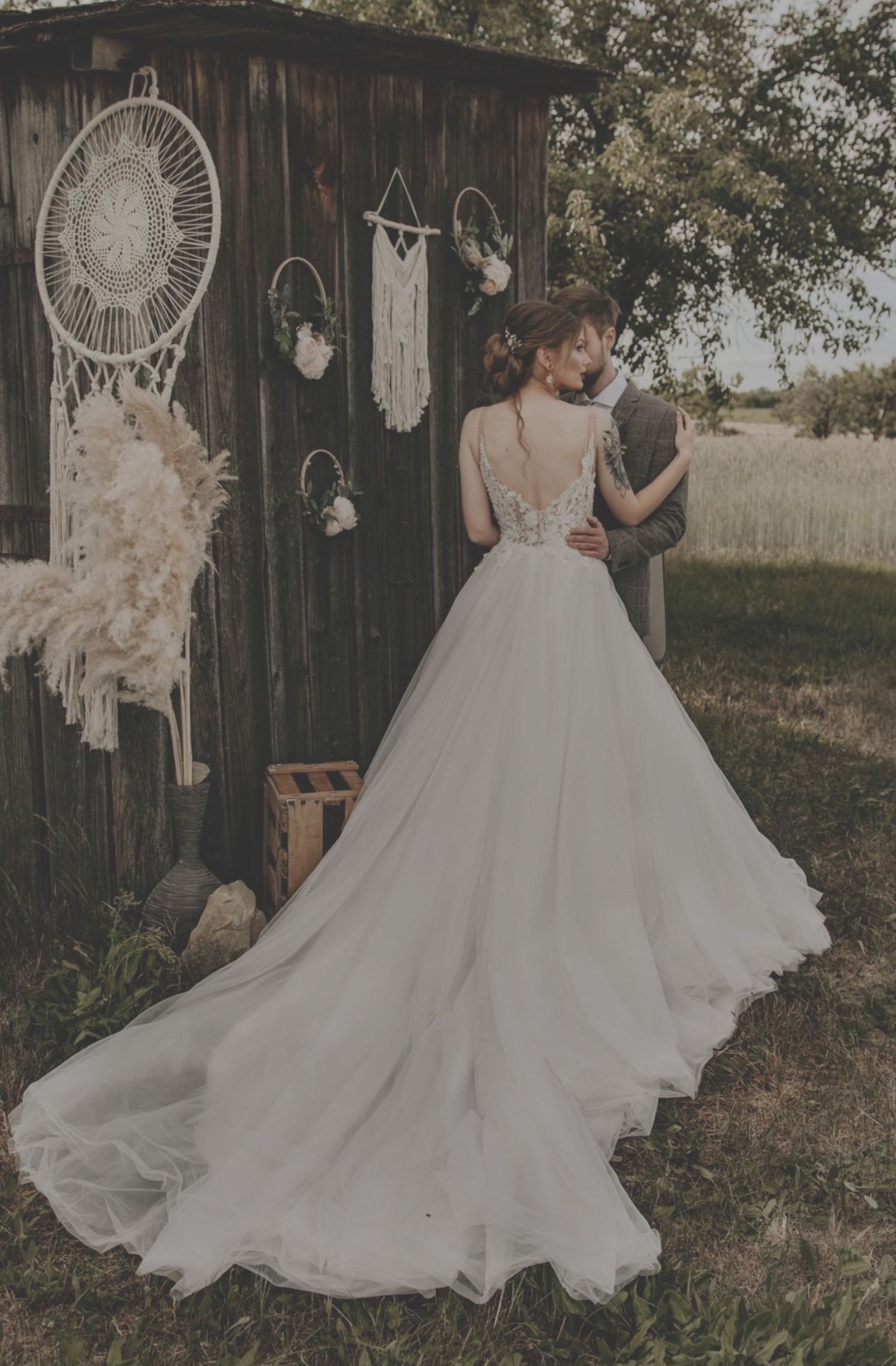 Eine Braut und ein Bräutigam posieren vor einem Holzgebäude für ein Foto.