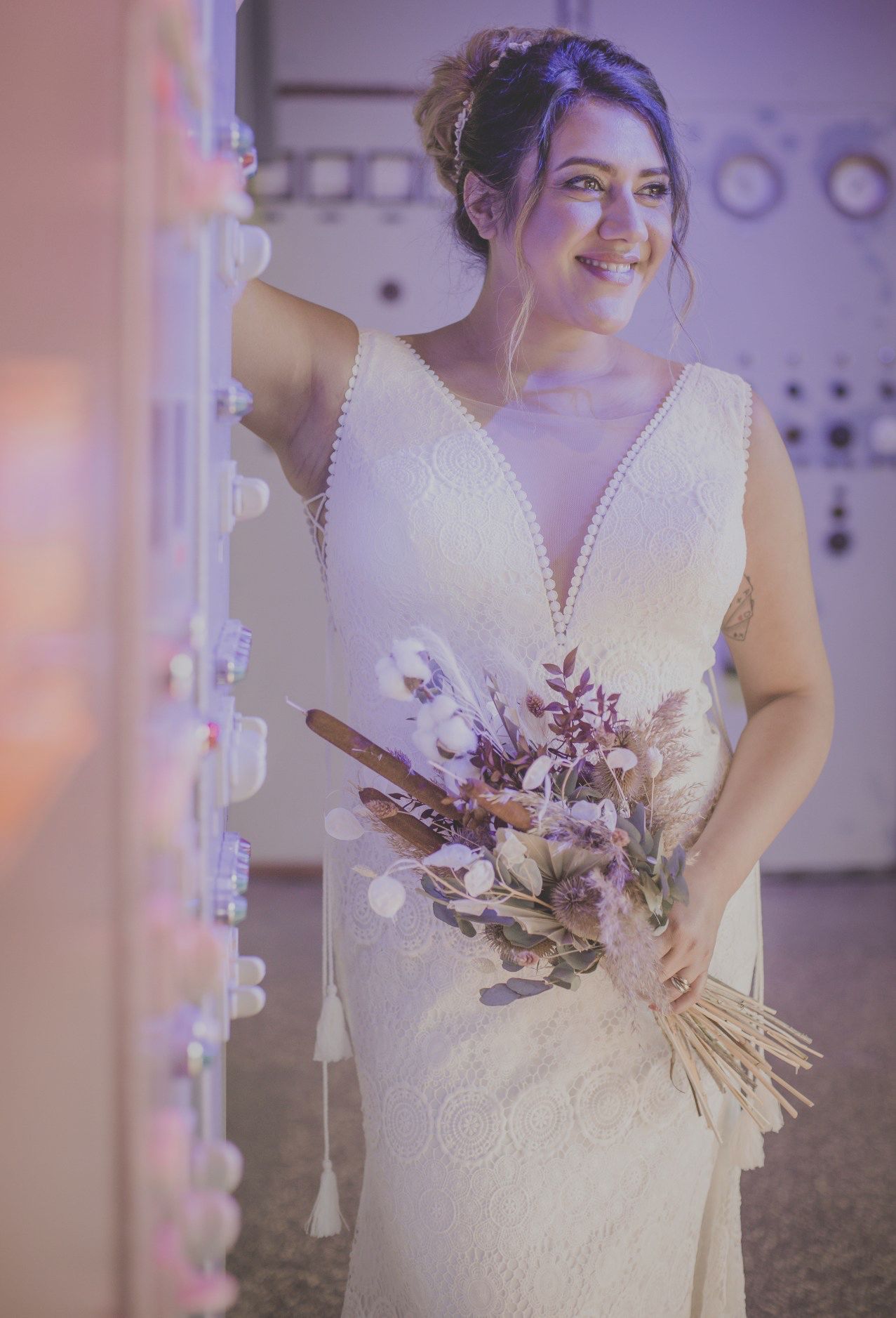 Eine Braut im Brautkleid hält einen Blumenstrauß.