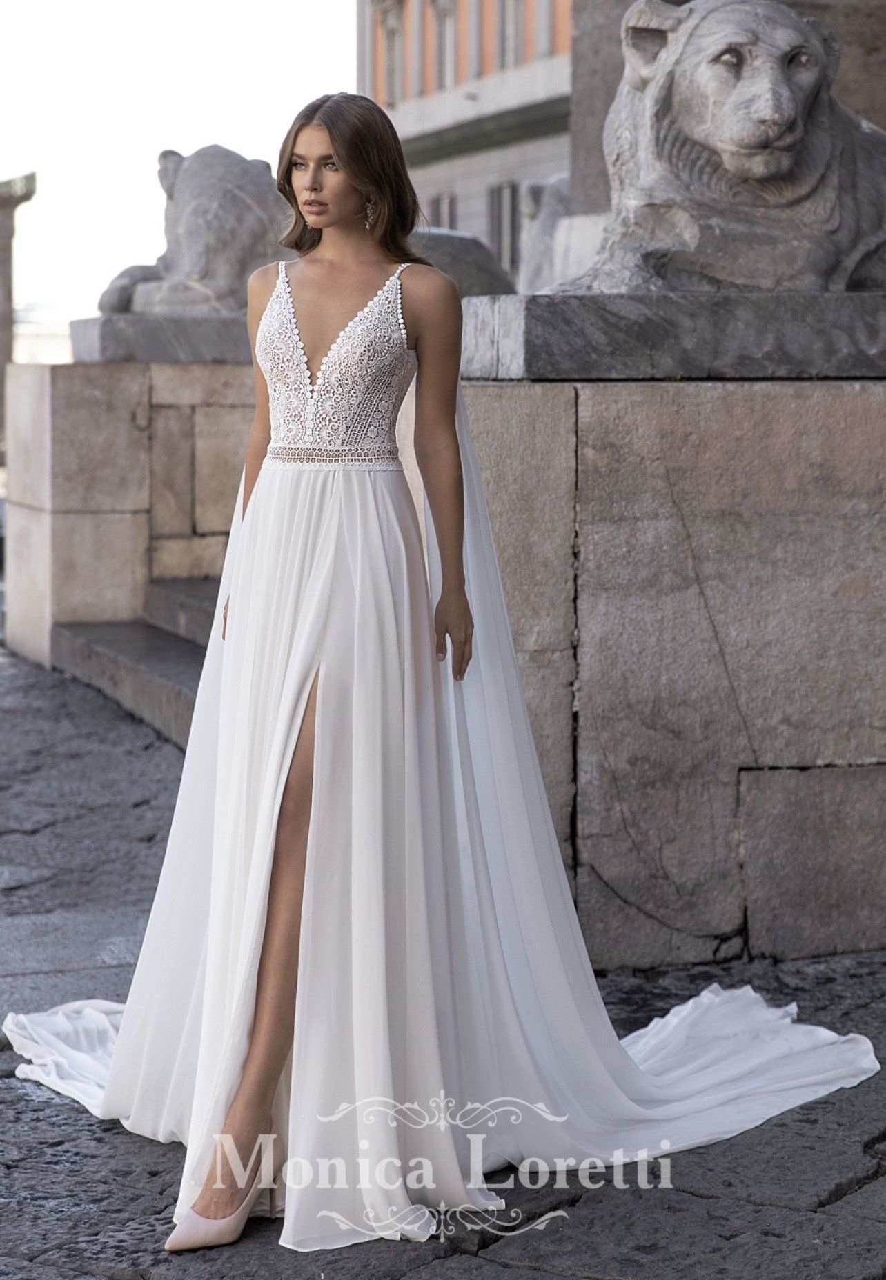 Eine Frau trägt ein weißes Brautkleid mit hohem Schlitz.