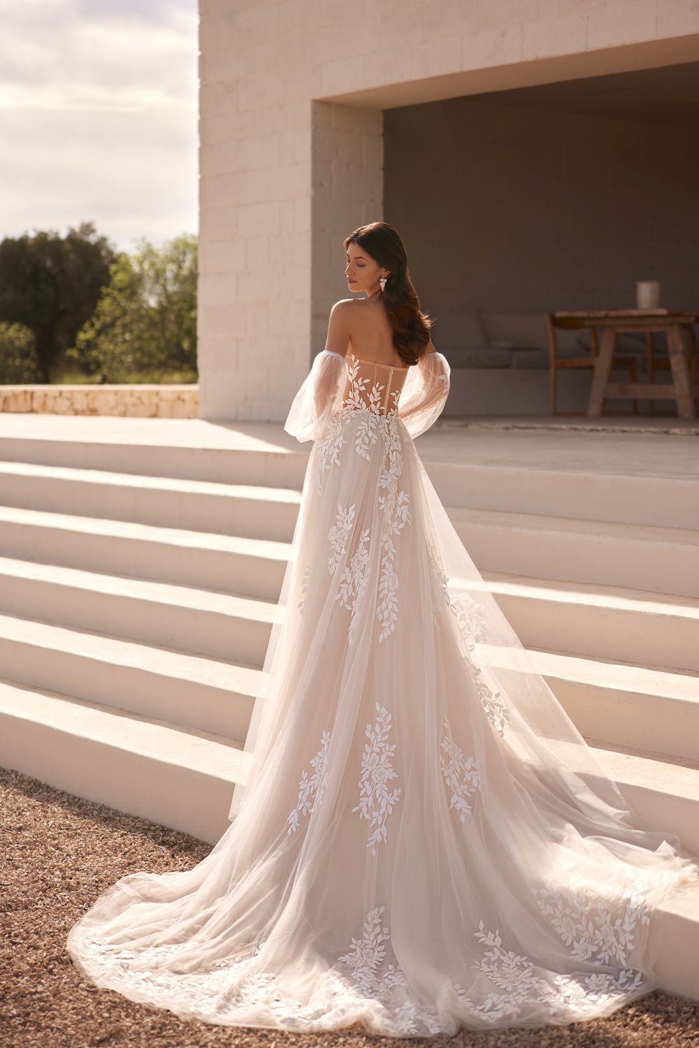Eine Frau in einem Brautkleid steht auf einer Treppe.