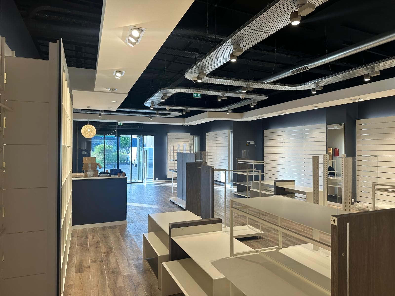 A large empty store with lots of shelves and a counter.