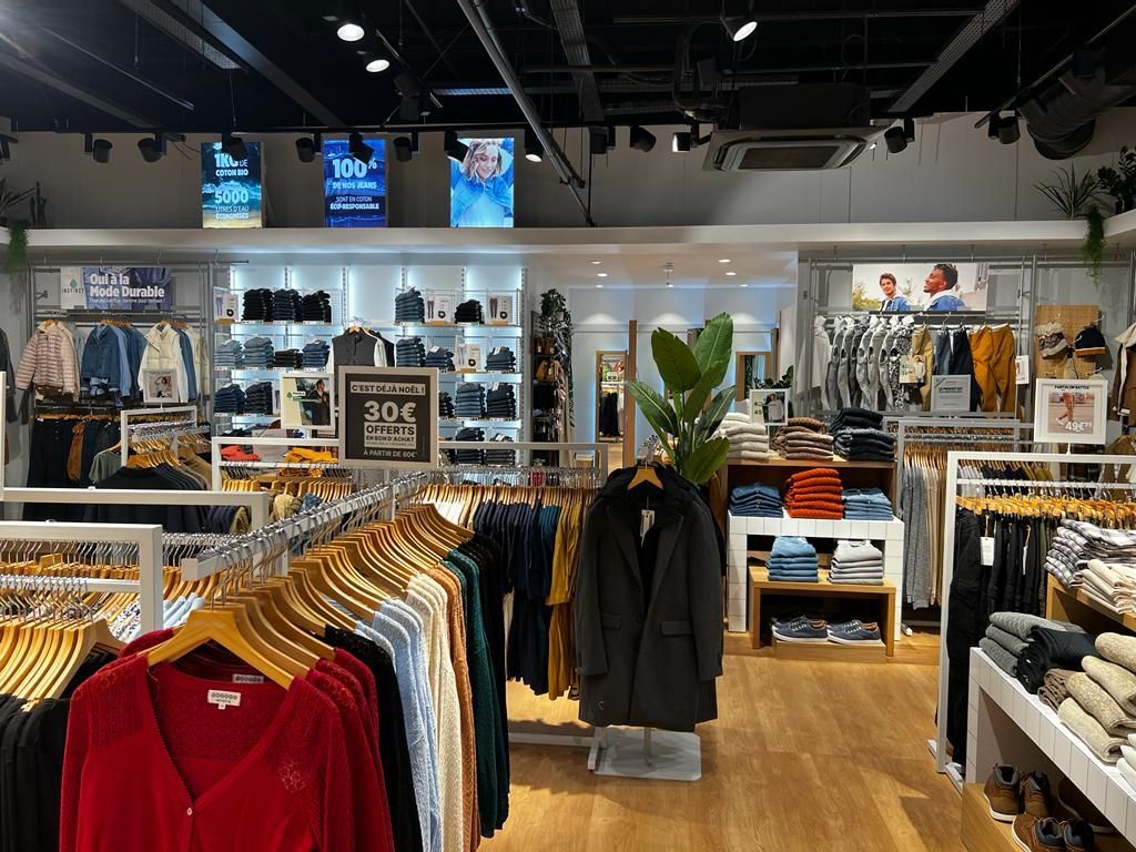 A clothing store with a lot of clothes hanging on racks.