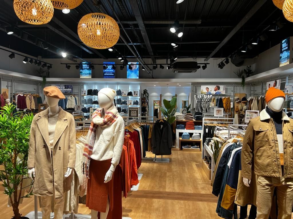A clothing store with mannequins and clothes on display.