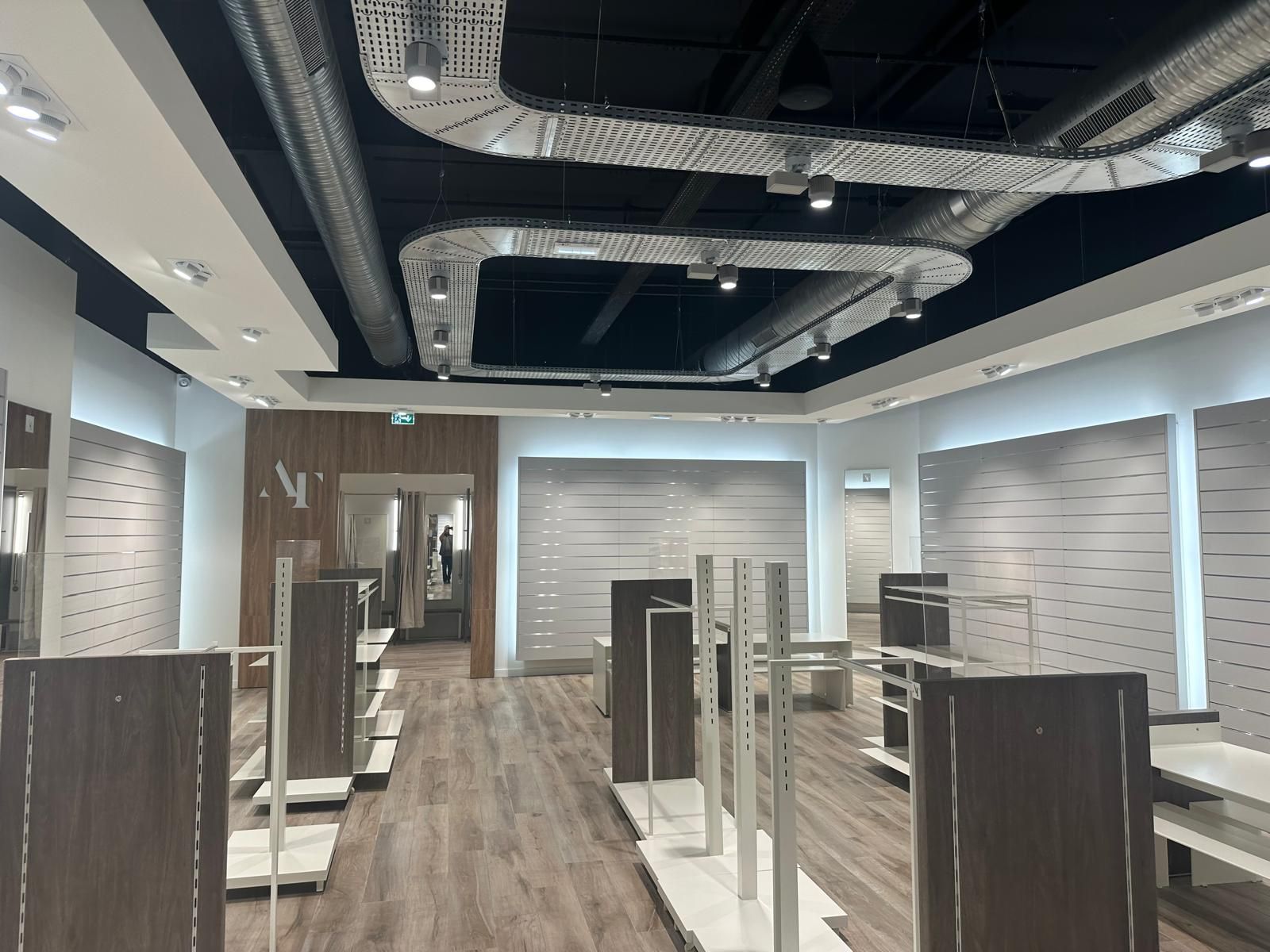 A large empty store with a lot of shelves and a ceiling.