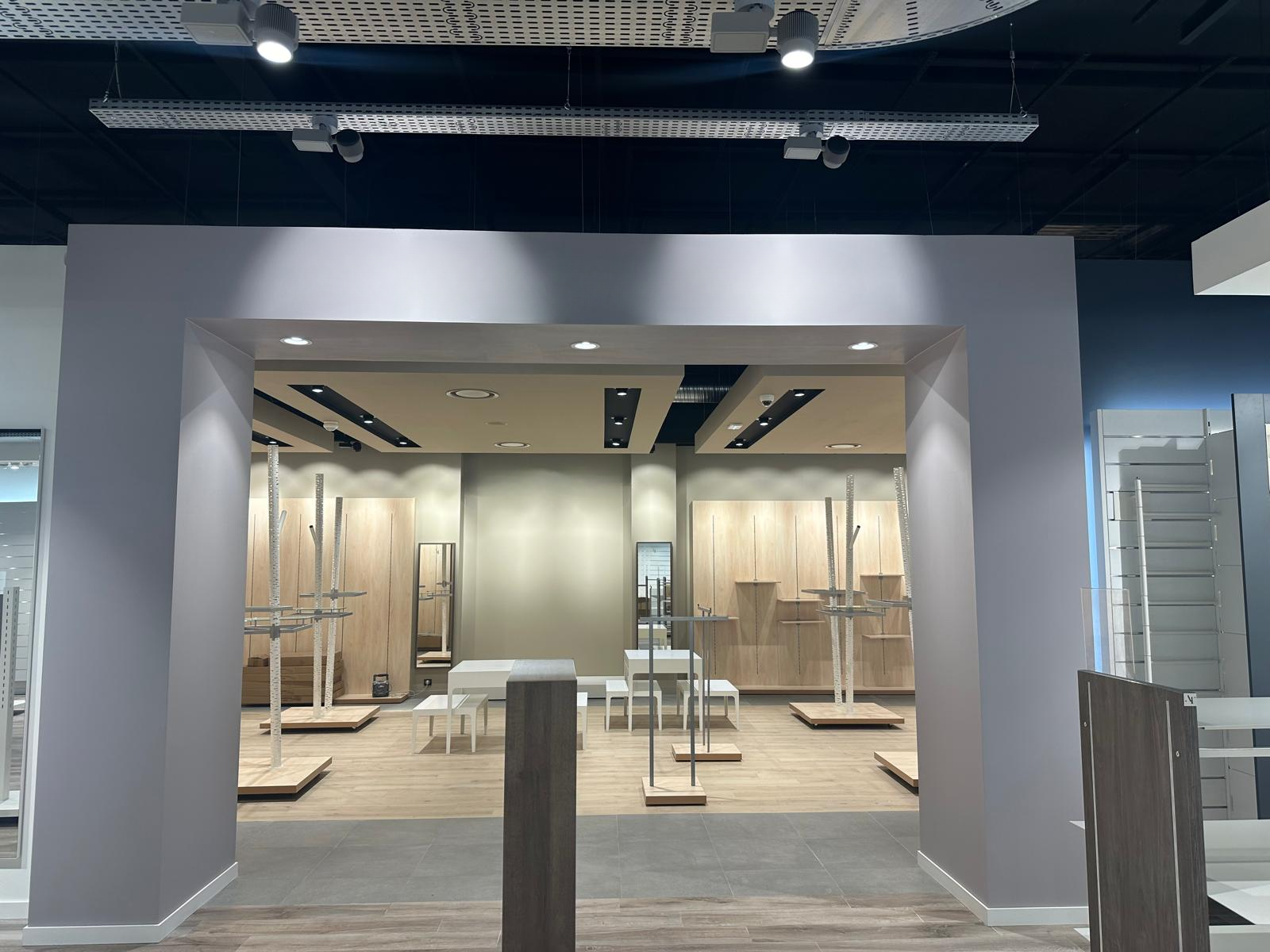 An empty store with a wooden floor and white walls