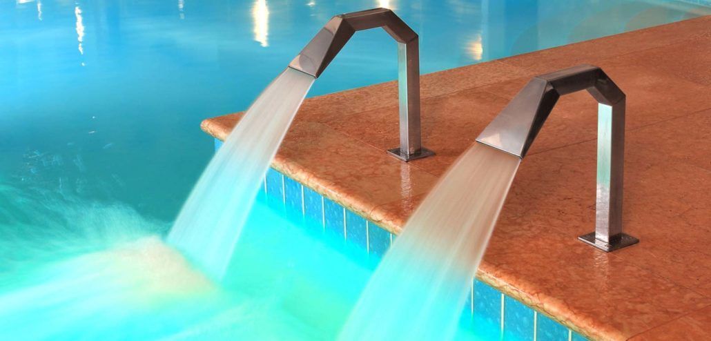 Due getti d'acqua escono da una piscina.