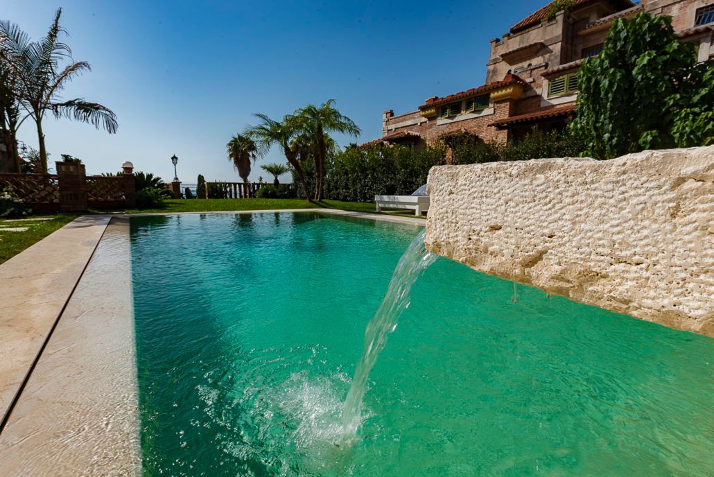 Una piscina con una cascata al centro.