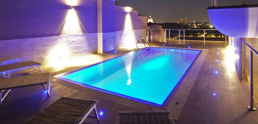 Una grande piscina è illuminata di notte.