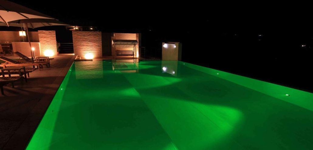 Una piscina è illuminata con luci verdi di notte.