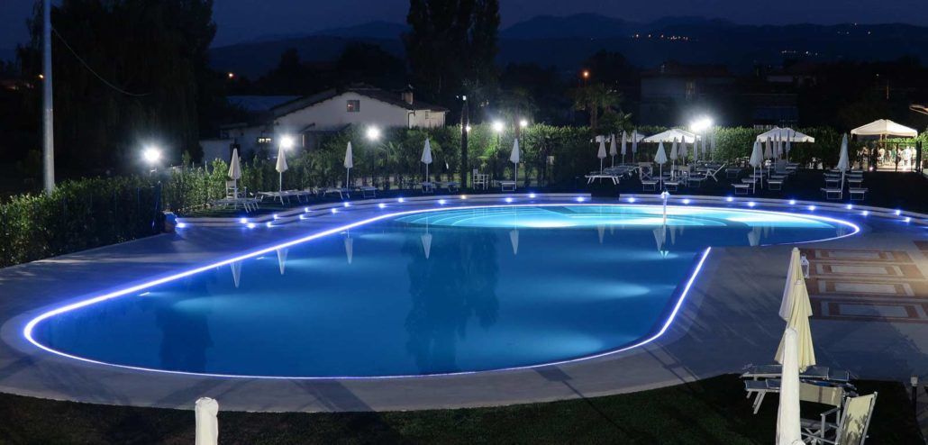 Una grande piscina è illuminata di notte.