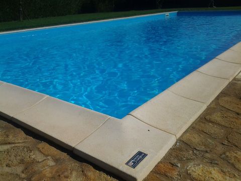 Una grande piscina con acqua azzurra e bordo bianco