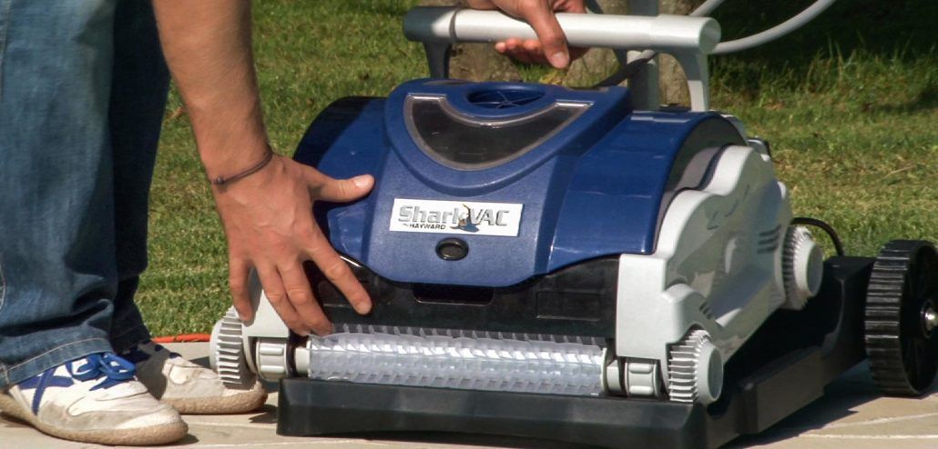 Una persona sta utilizzando un robot pulitore per pulire una piscina.