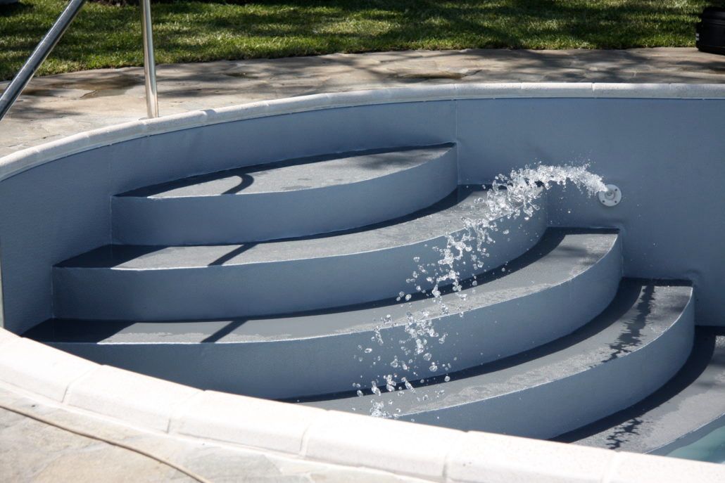 Una piscina con scale e acqua che esce da esse